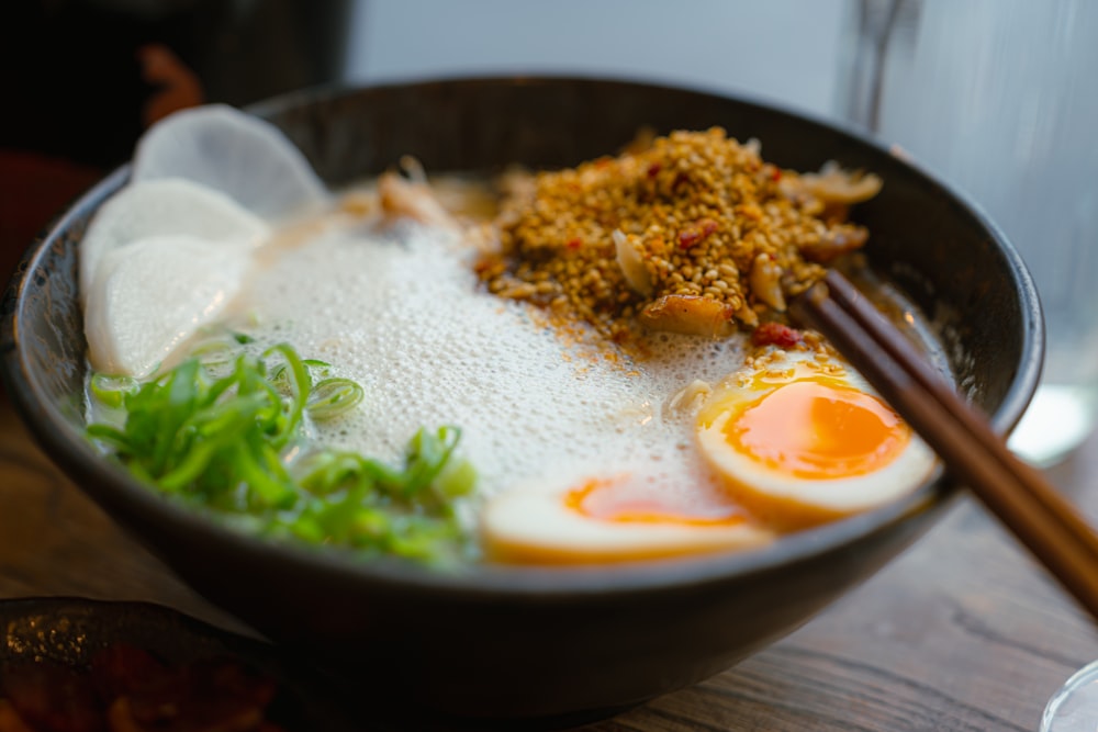 a bowl of food with chopsticks on a table