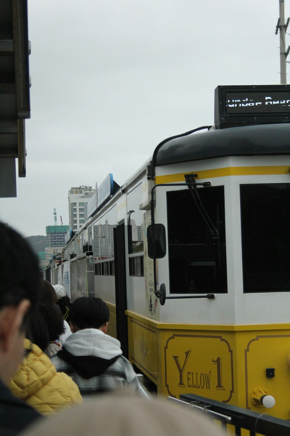 a yellow and white train traveling down train tracks