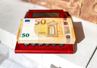 a 50 euro bill sitting on top of a red machine