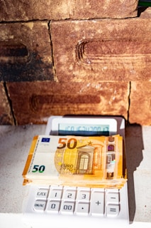 a calculator sitting next to a brick wall