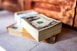 a stack of money sitting on top of a sidewalk