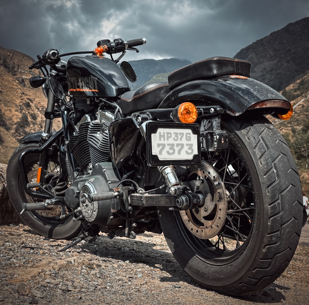 a black motorcycle parked on a dirt road