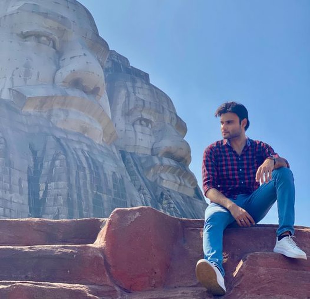 a man sitting on top of a rock formation