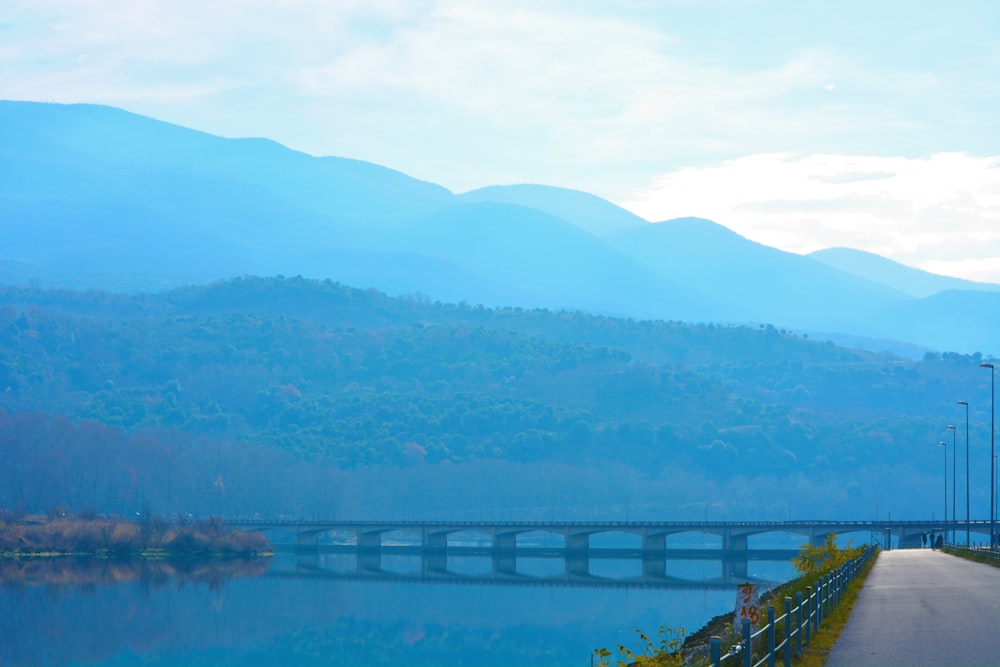 a bridge over a body of water with mountains in the background