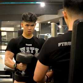 a man holding a dumbbell while standing next to another man