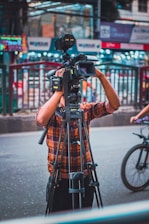 a man standing next to a bike holding a camera