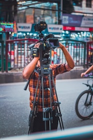 a man standing next to a bike holding a camera
