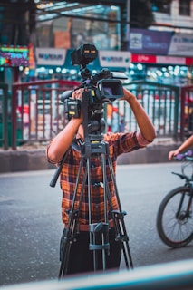 a man standing next to a bike holding a camera