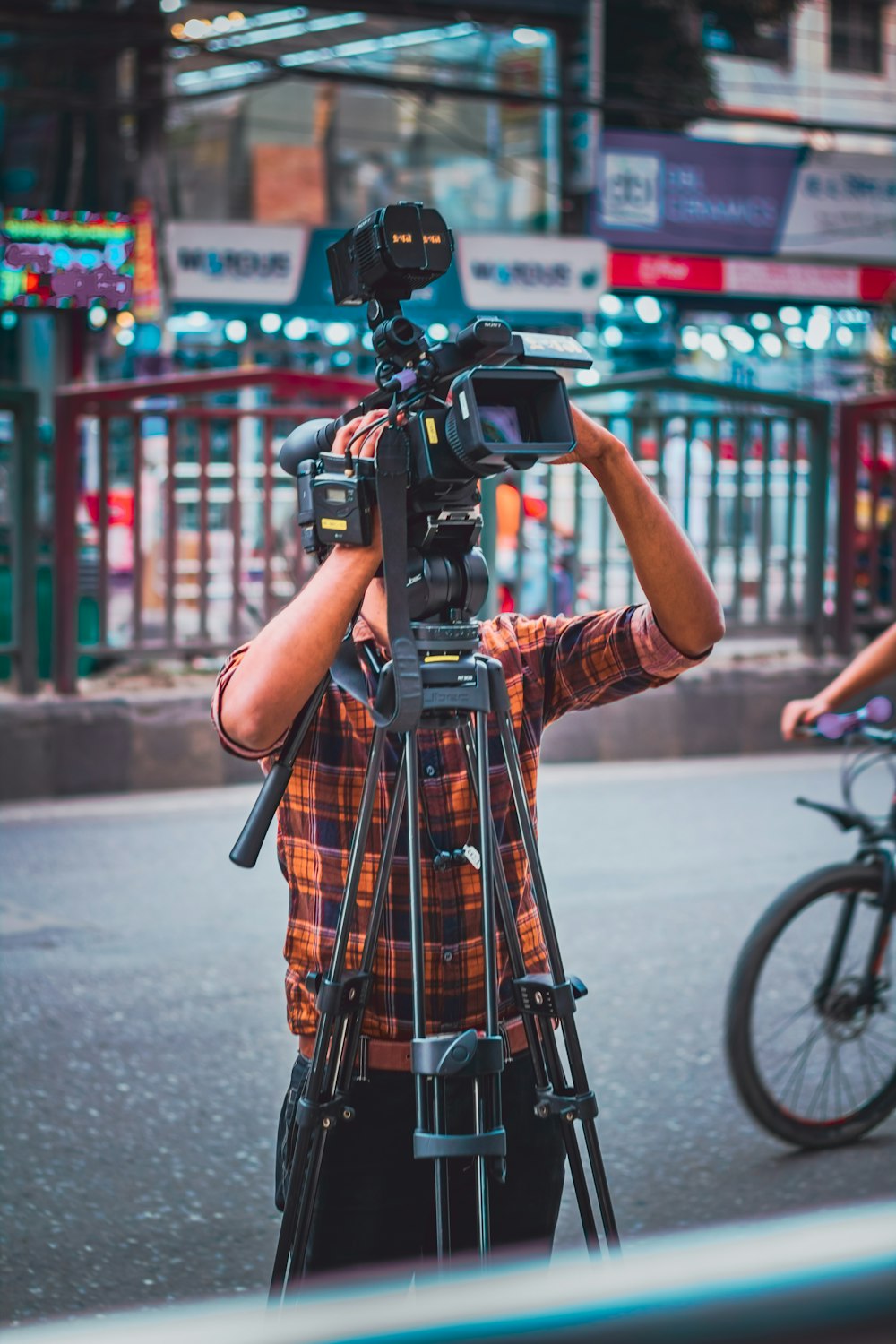 a man standing next to a bike holding a camera