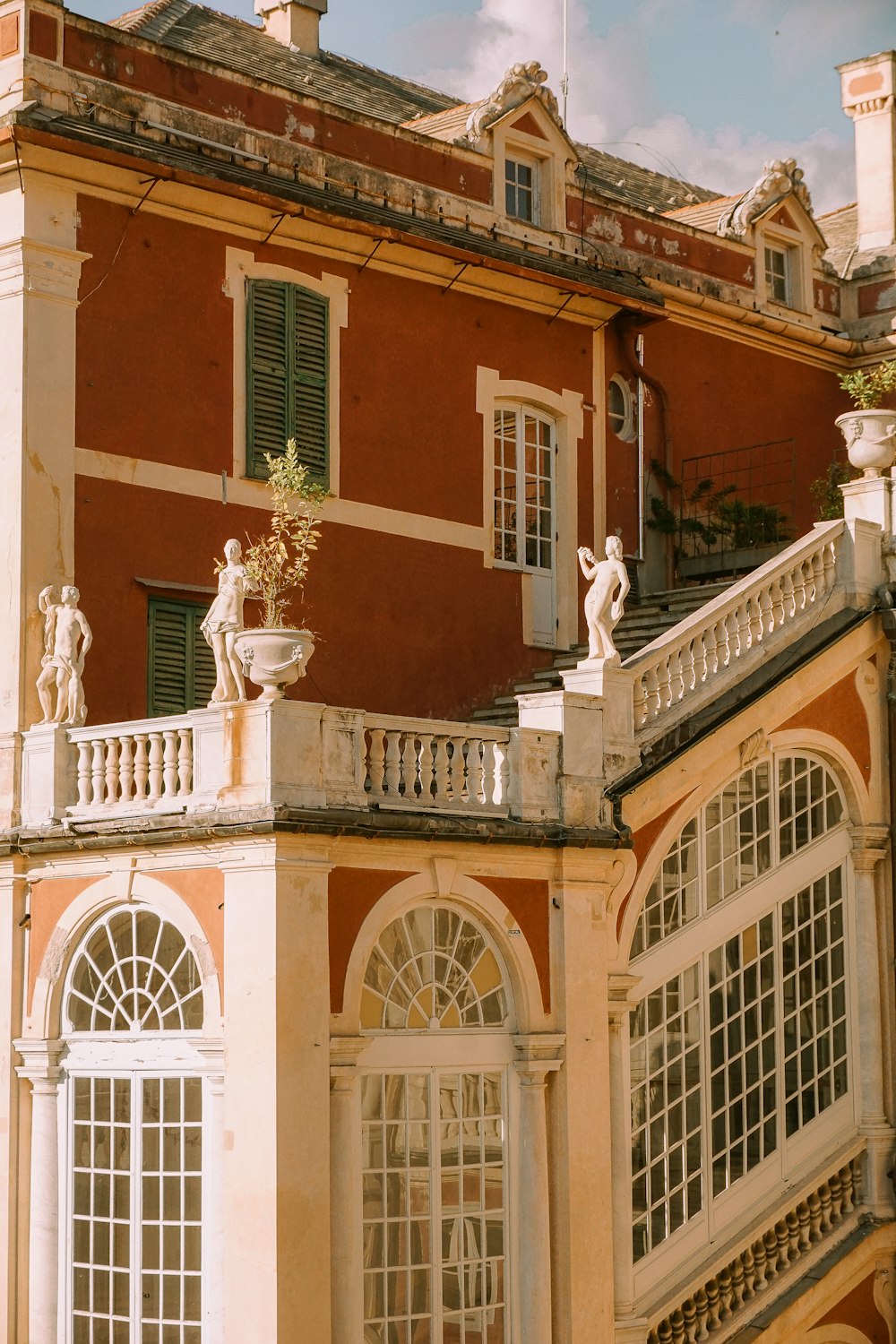 a large building with a balcony and statues on the top of it