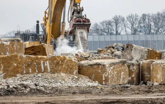 a bulldozer digging through a pile of rubble