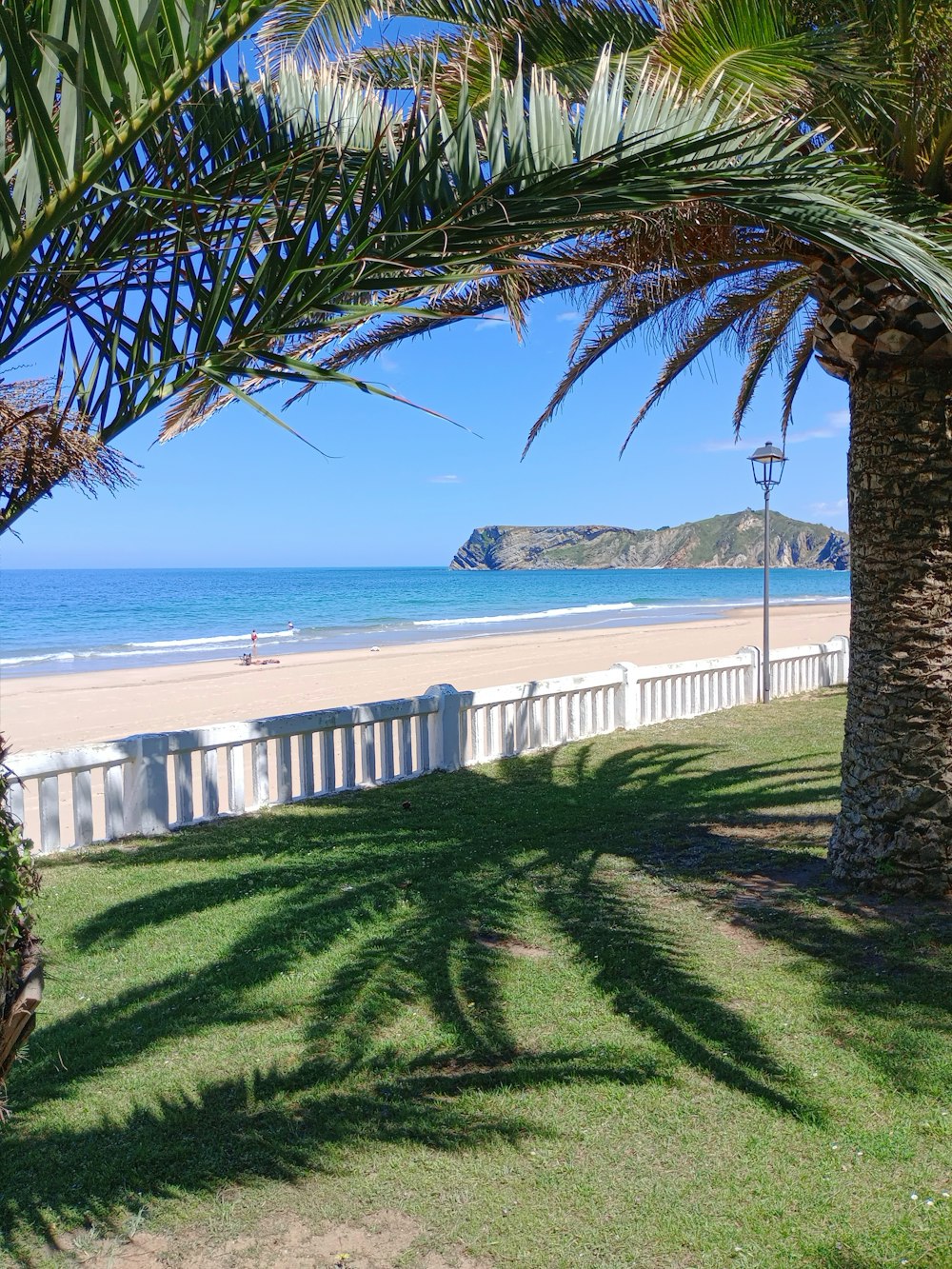 a view of a beach from behind a fence