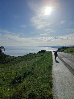 a person riding a motorcycle down a road next to the ocean