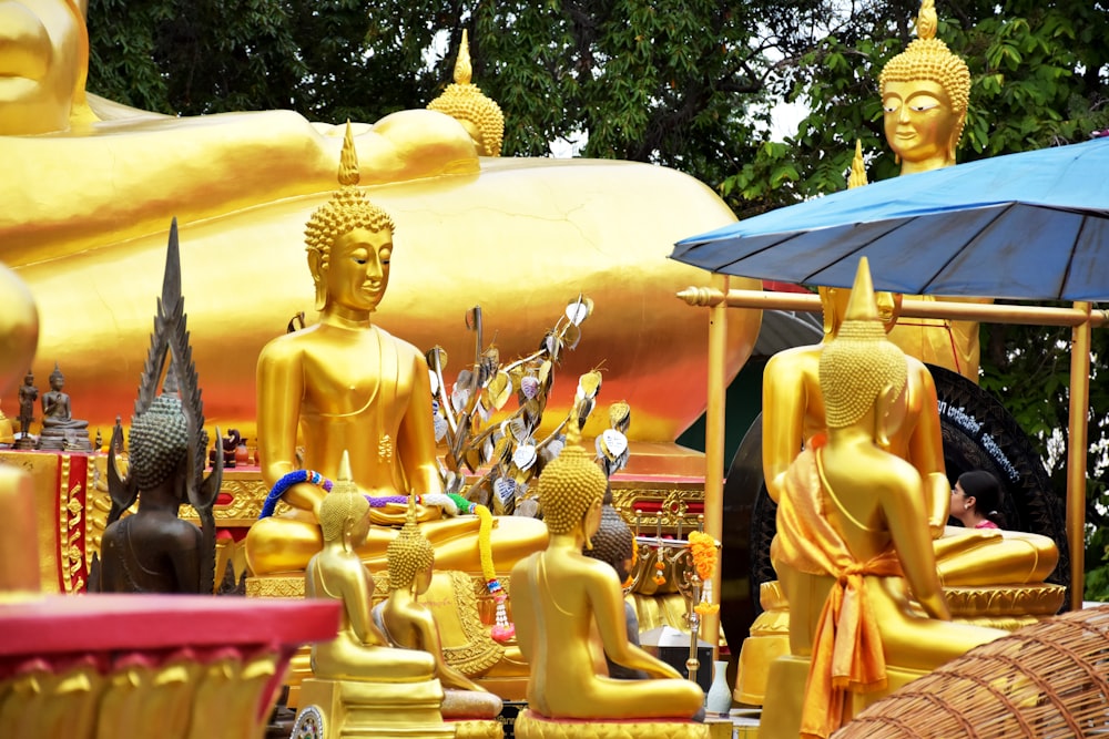 a group of golden buddha statues sitting next to each other