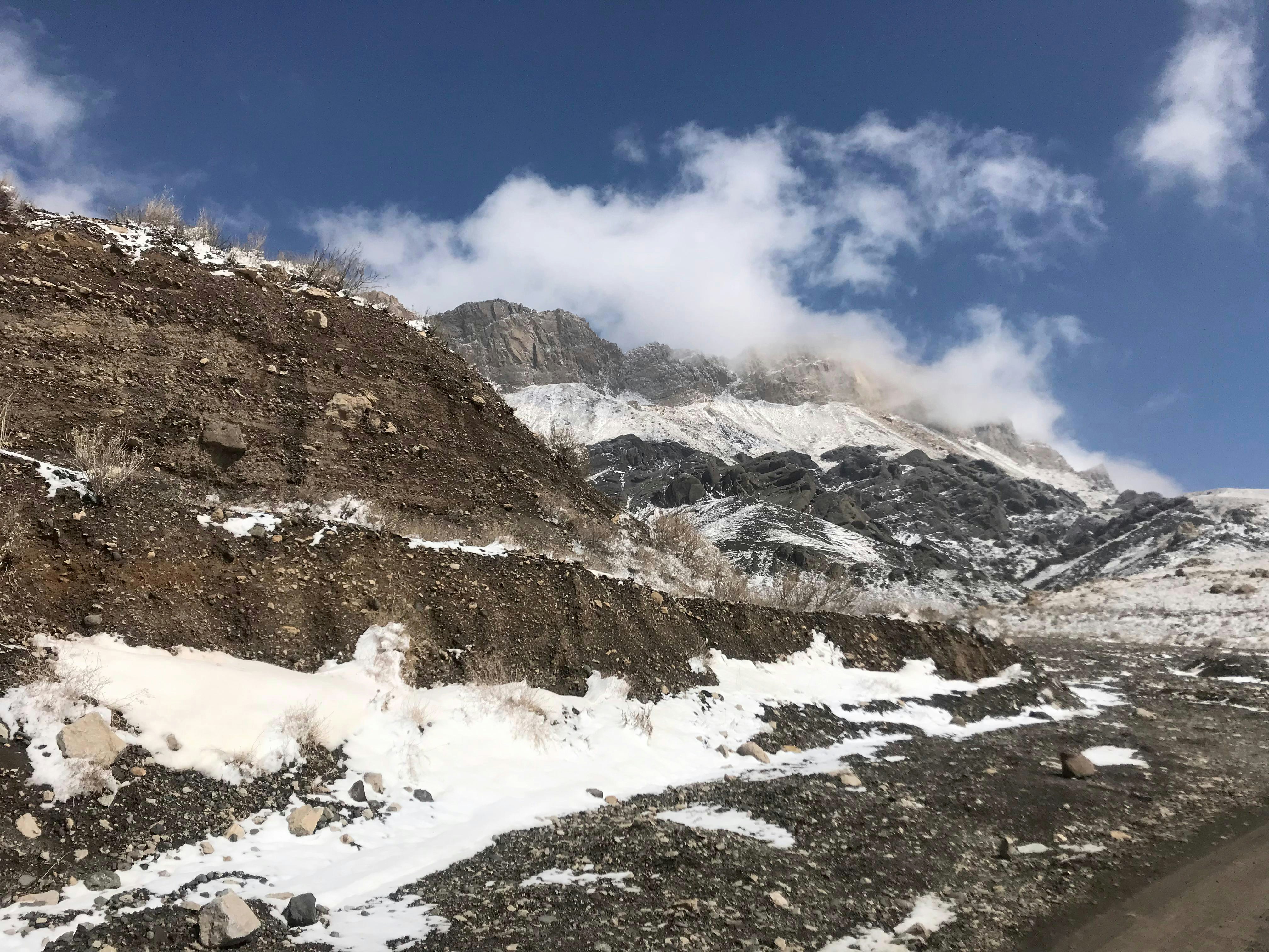 a snow covered mountain with a road going through it