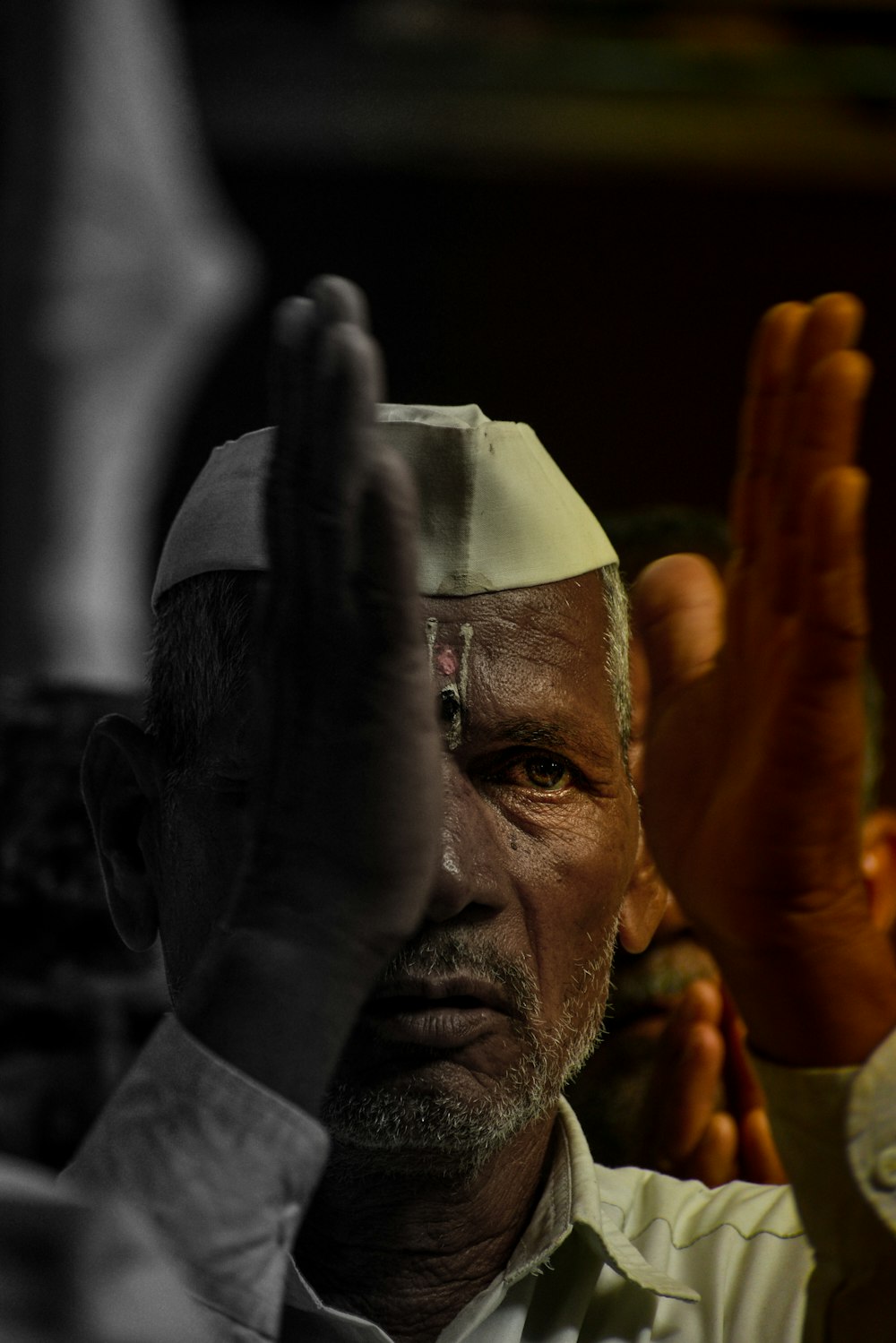 a man wearing a white hat and holding his hand up