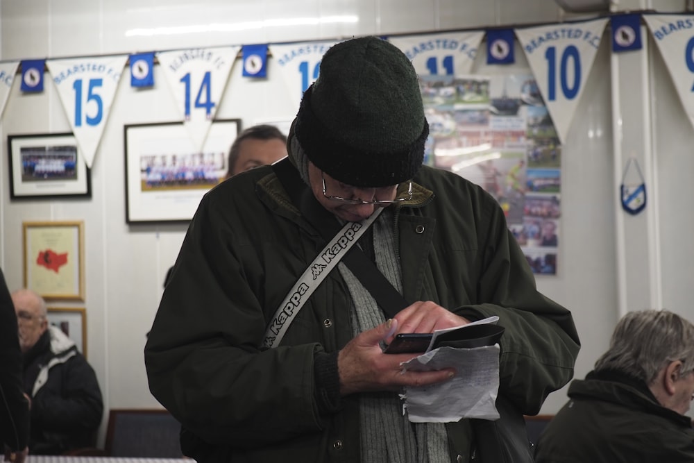 a man standing in a room looking at a piece of paper