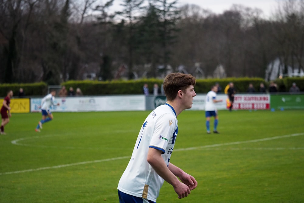 a young man standing on top of a soccer field