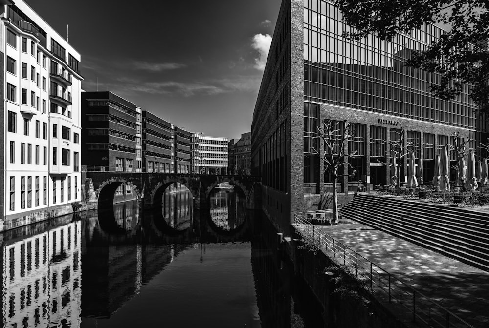 a black and white photo of a bridge and buildings
