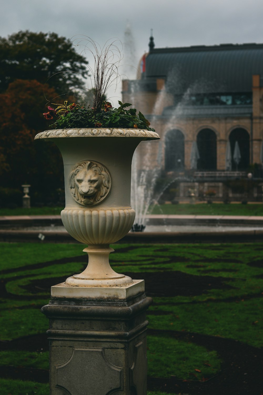 a large white vase sitting on top of a lush green field