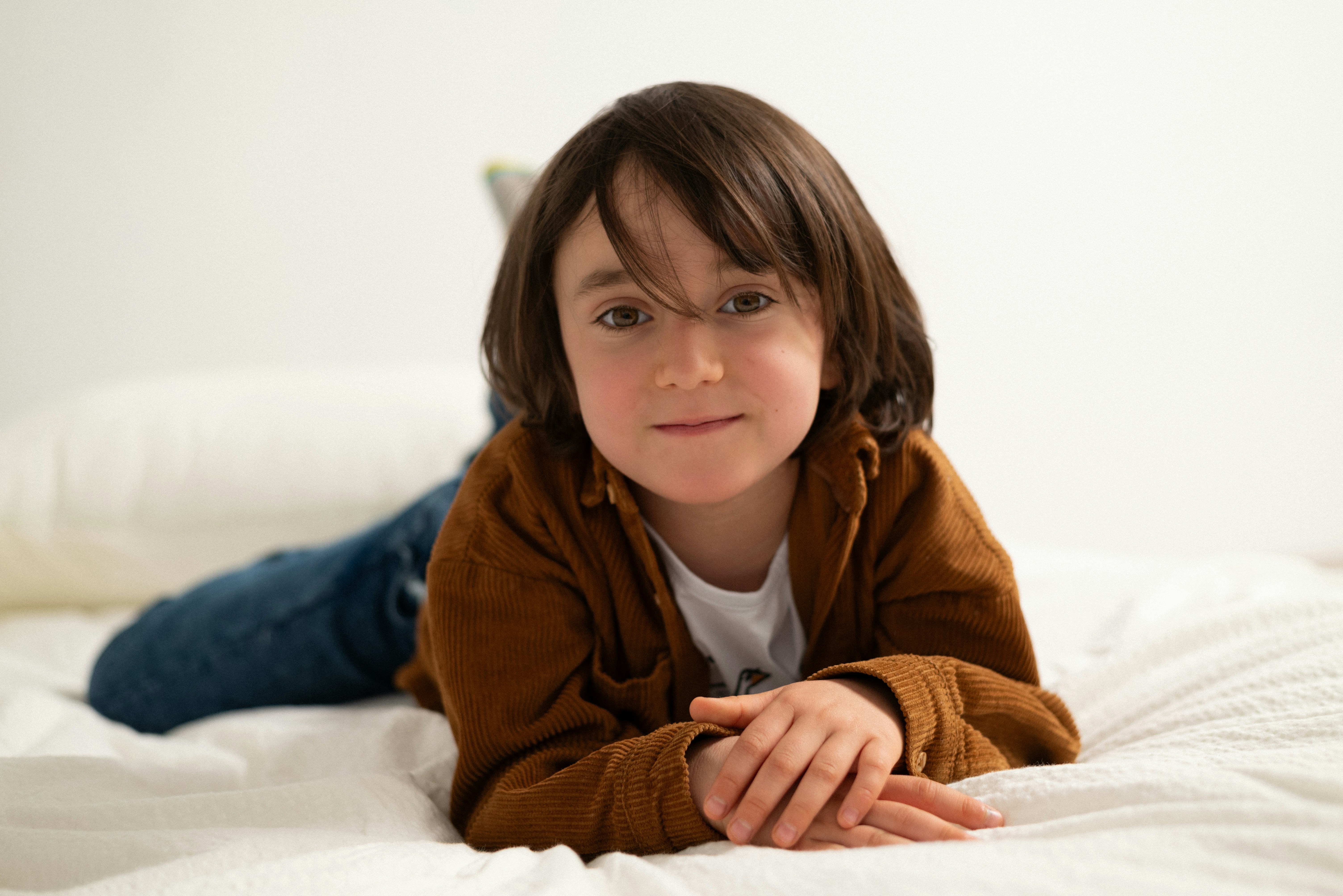 a little girl laying on top of a bed