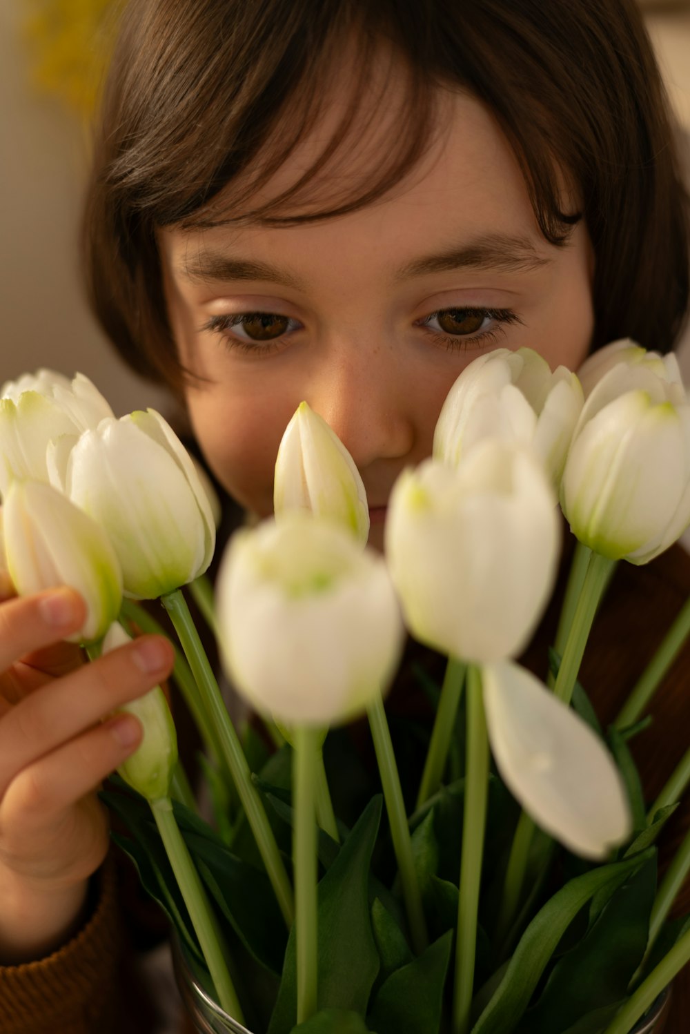 a little girl holding a bunch of white tulips