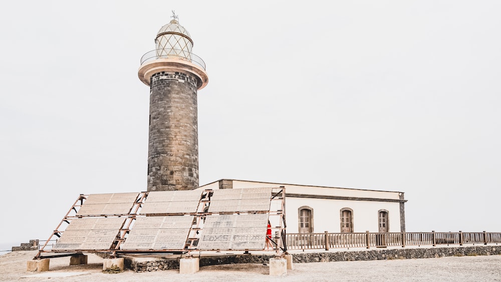 a large light house sitting on top of a sandy beach