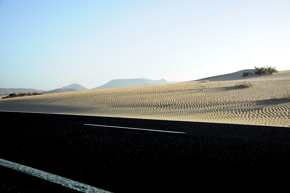 a car driving down a road in the desert