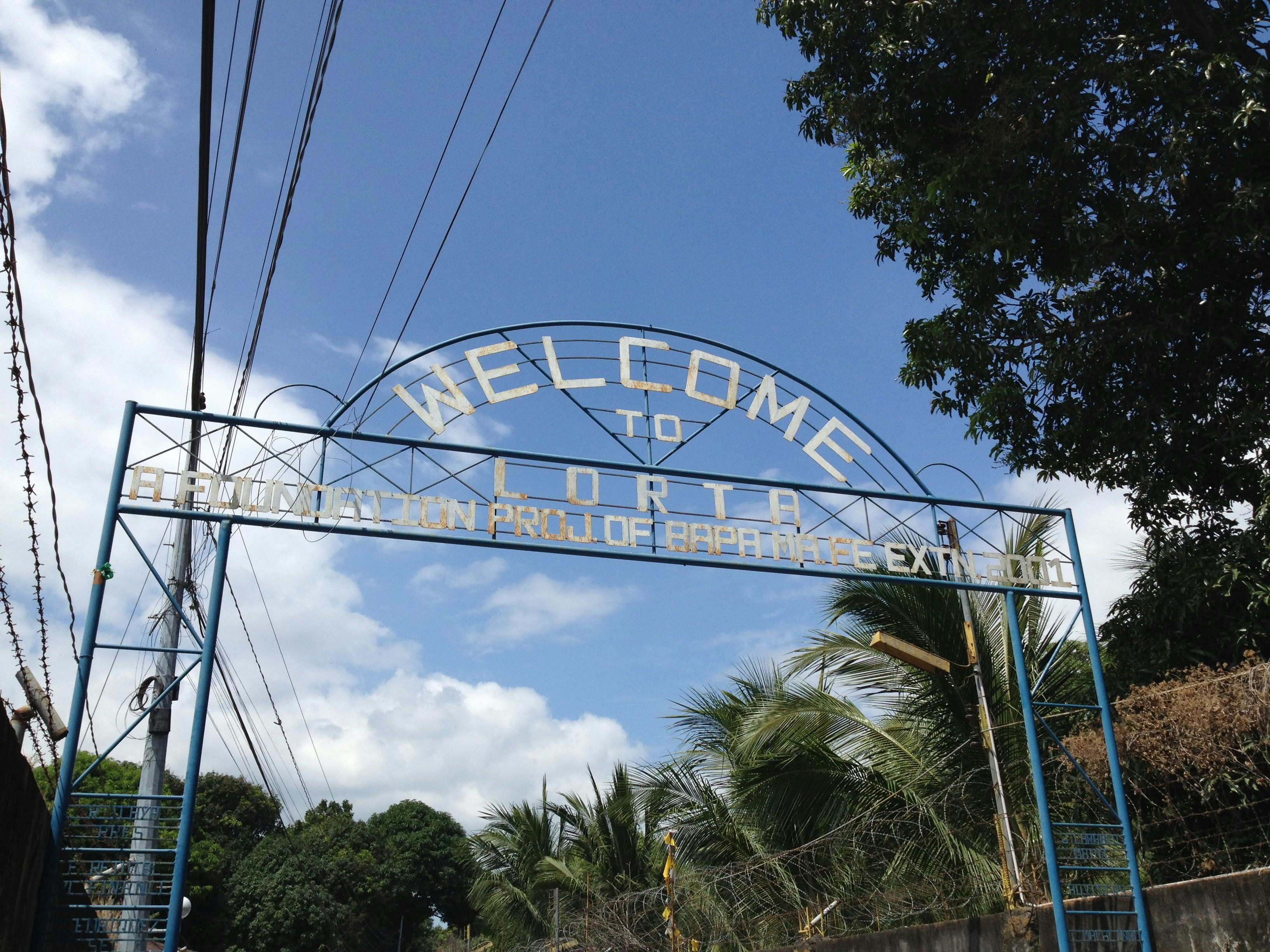 a welcome sign for a tropical resort on a sunny day