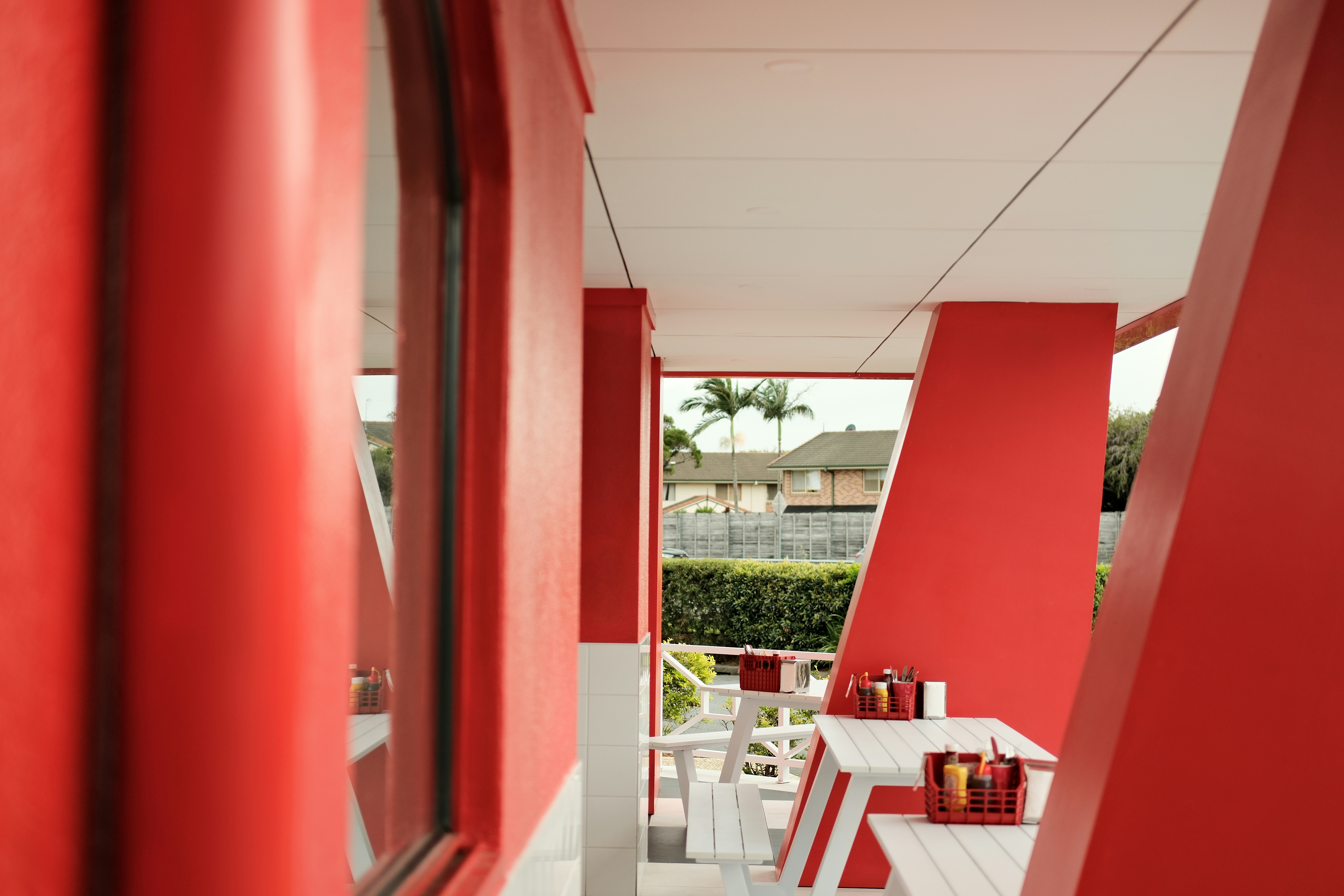 a red and white porch with a table and chairs