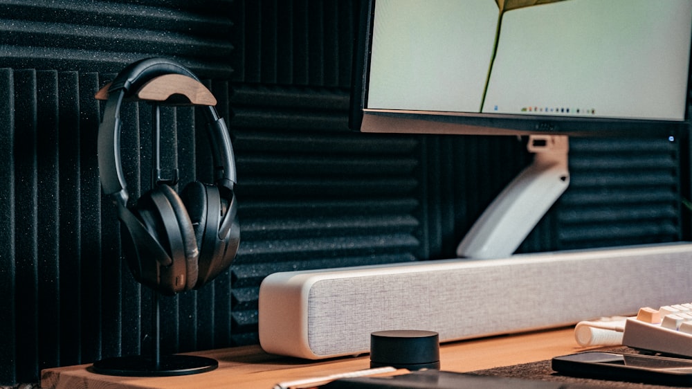 a computer monitor with headphones on a desk