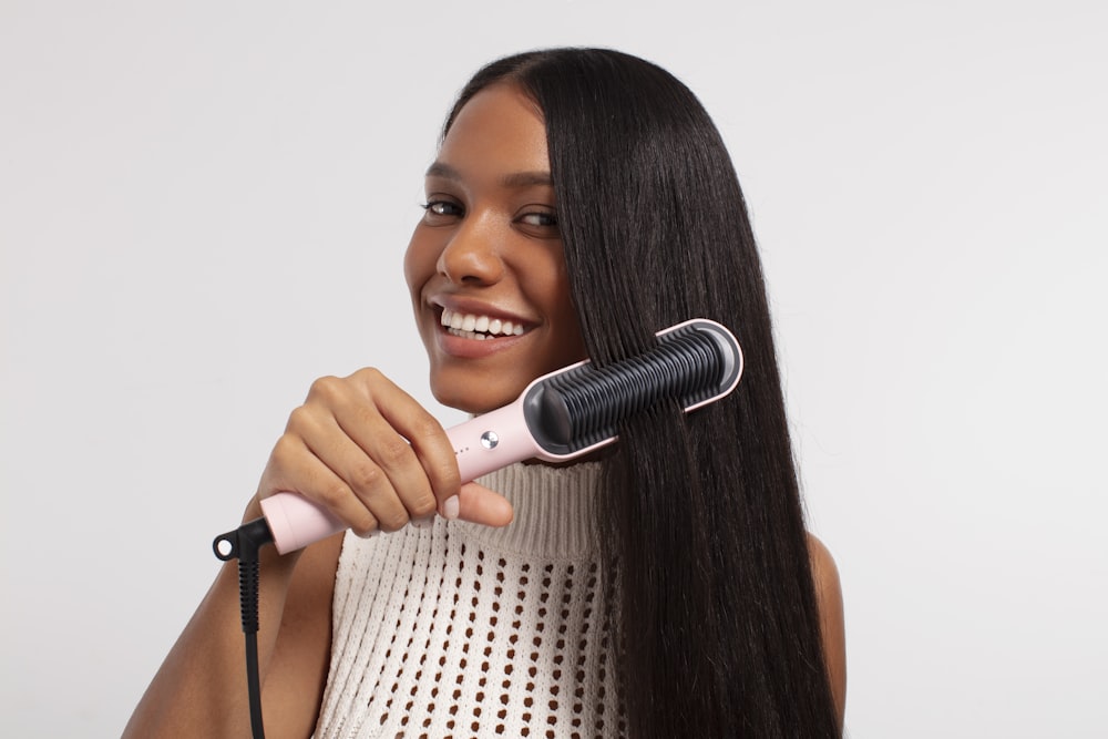 a woman using a hair dryer on her long hair