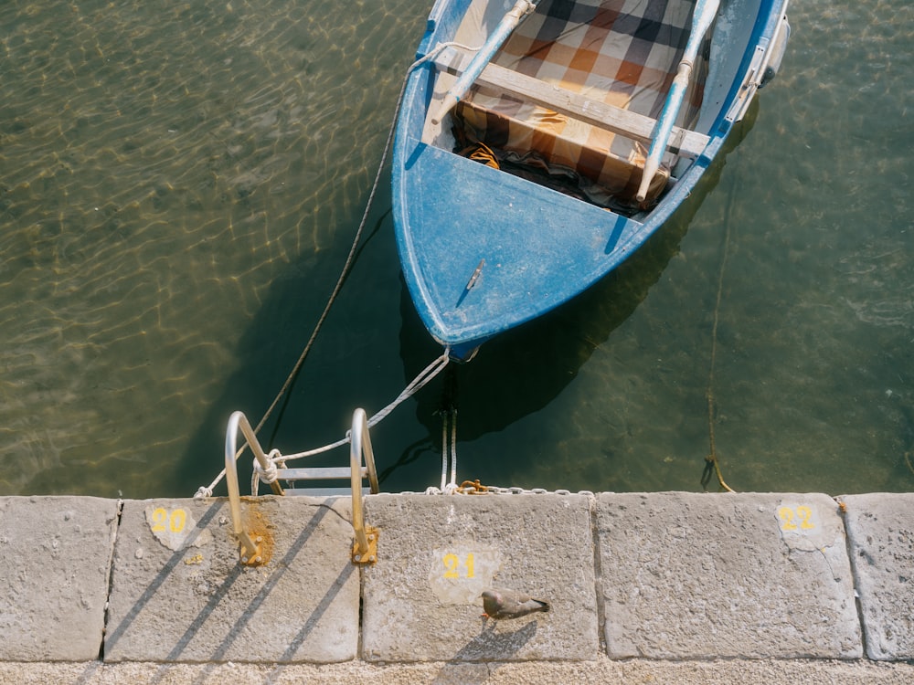 a small blue boat tied to a dock