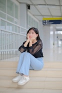 a woman sitting on the steps of an airport