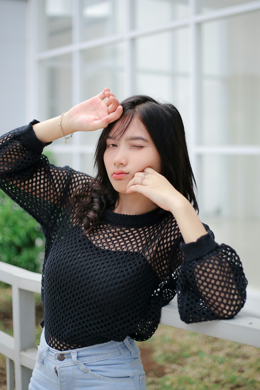 a woman in a black top leaning on a rail