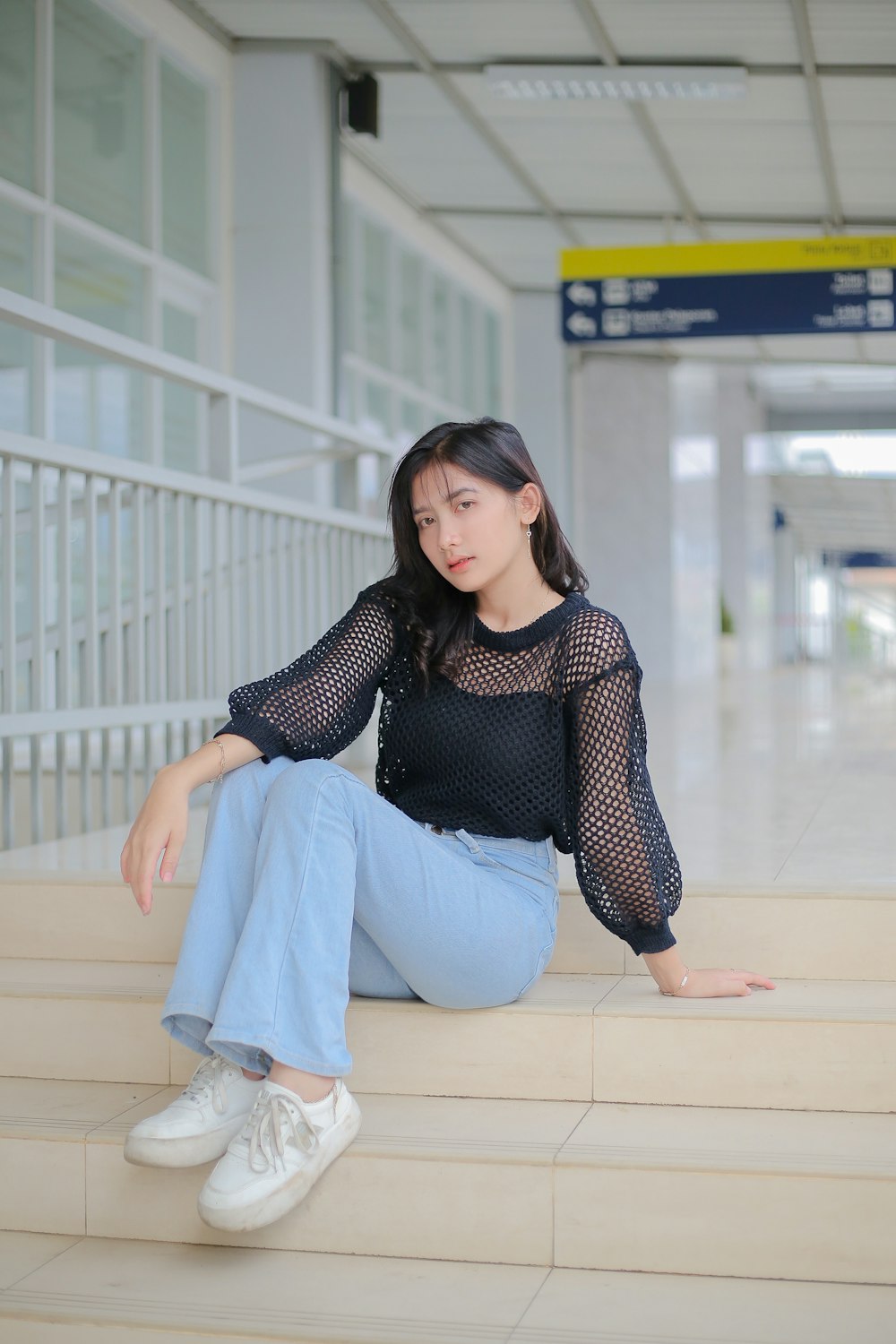 a woman sitting on the steps of an airport