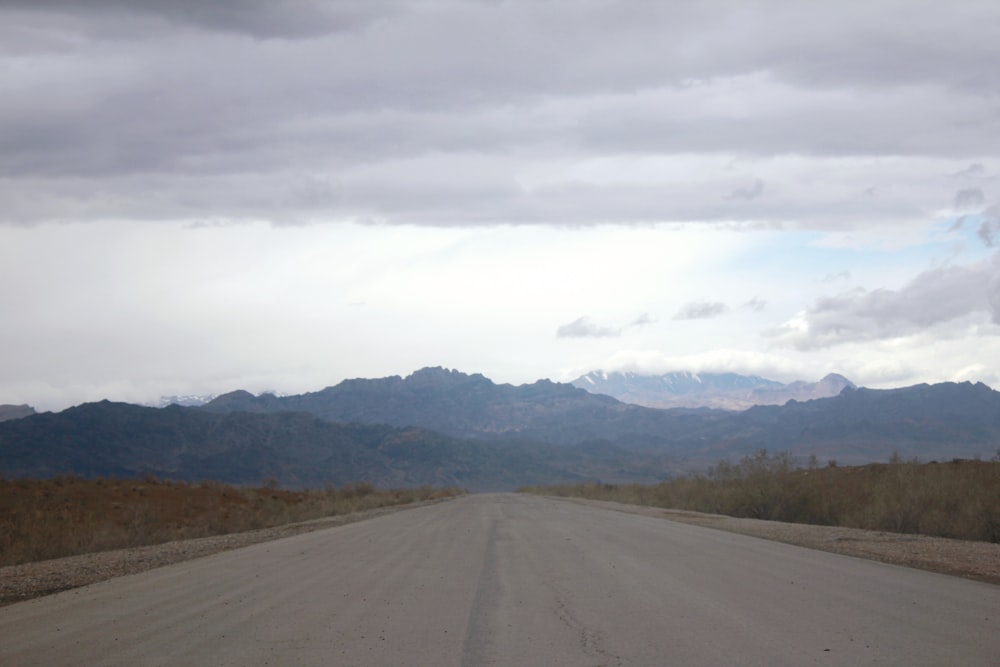 a dirt road with mountains in the background