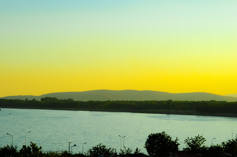 a large body of water with mountains in the background