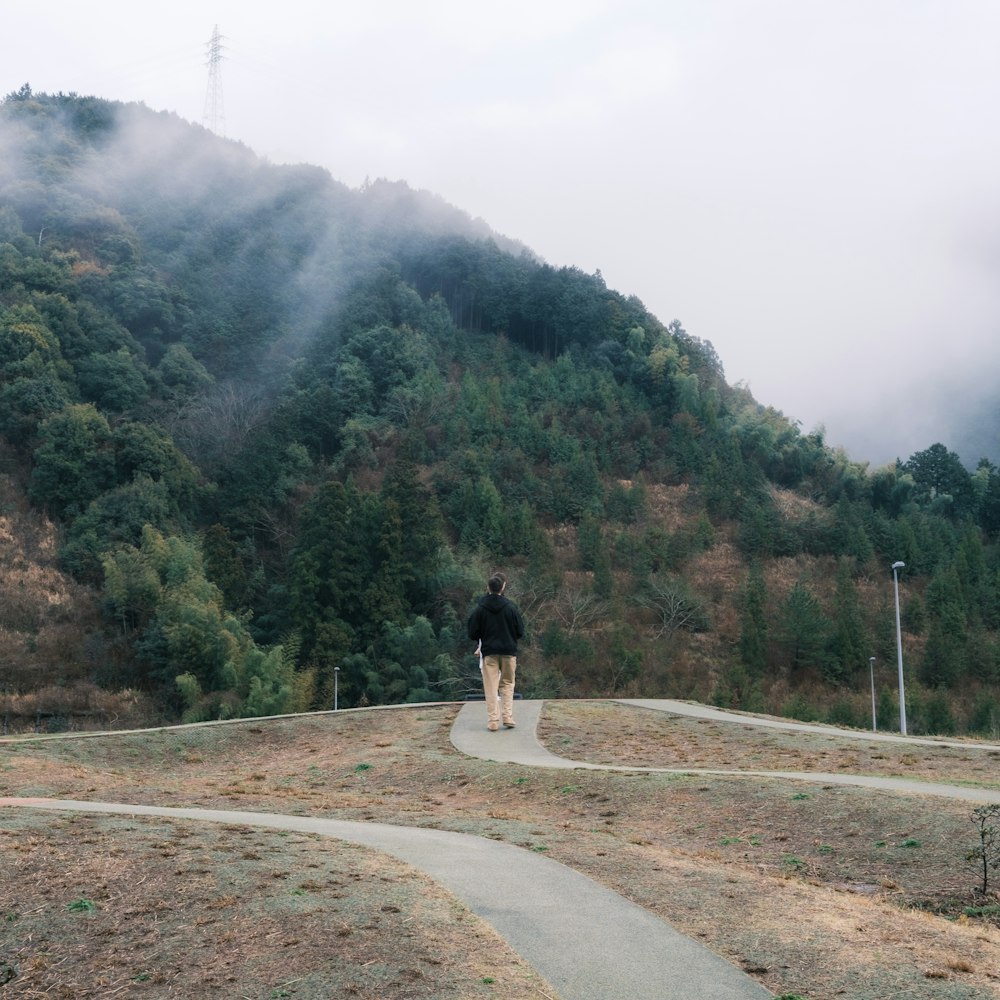 a person walking on a path near a mountain