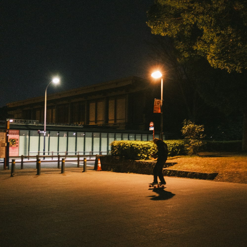 a man riding a skateboard down a street at night