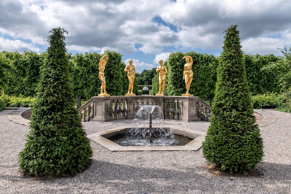 une fontaine entourée d’arbres et de statues