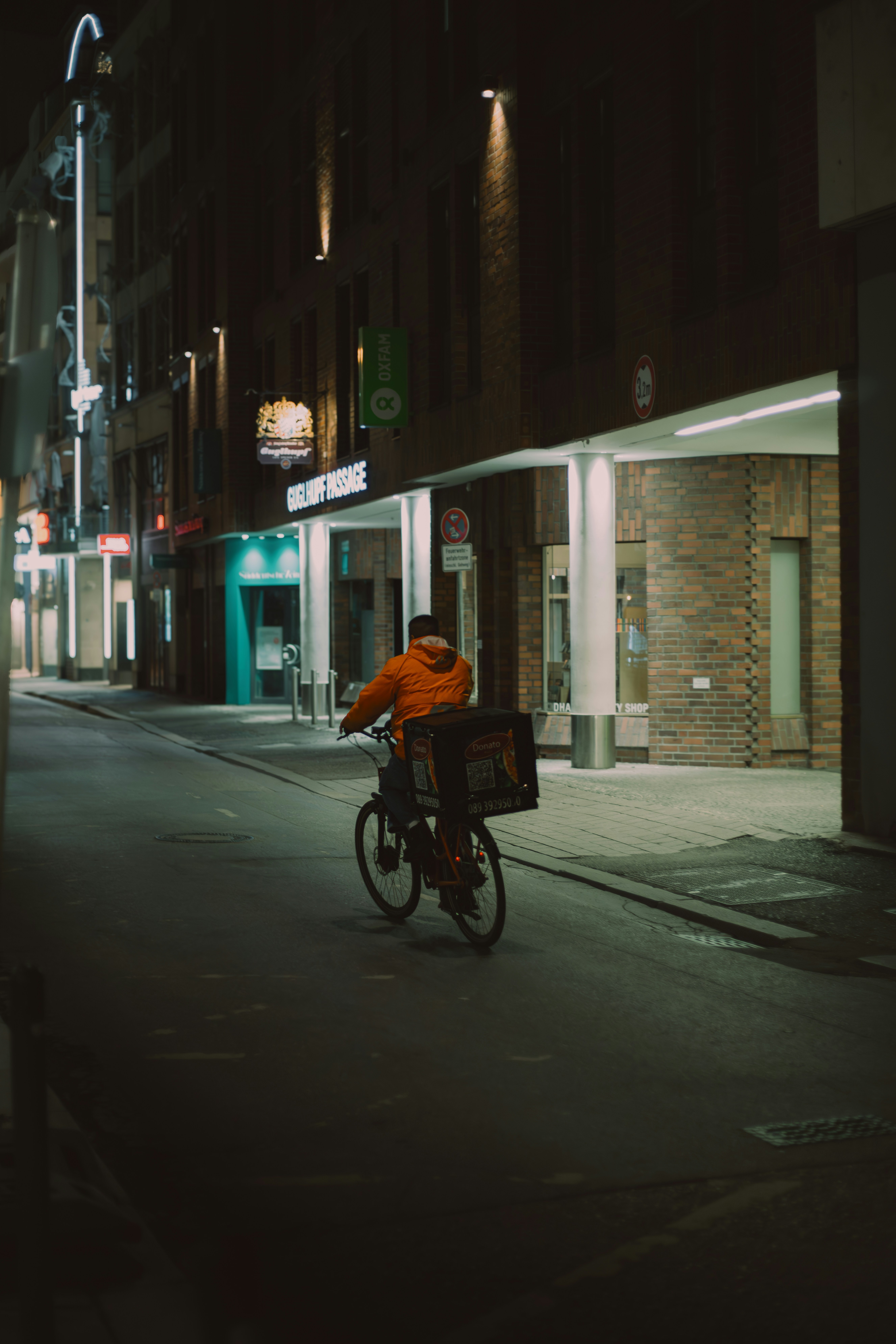 a man riding a bike down a street at night
