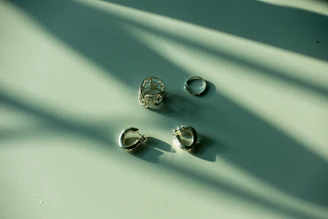 three pairs of earrings sitting on a table