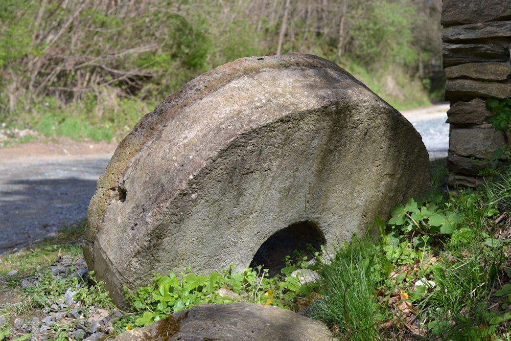 a large rock sitting next to a road