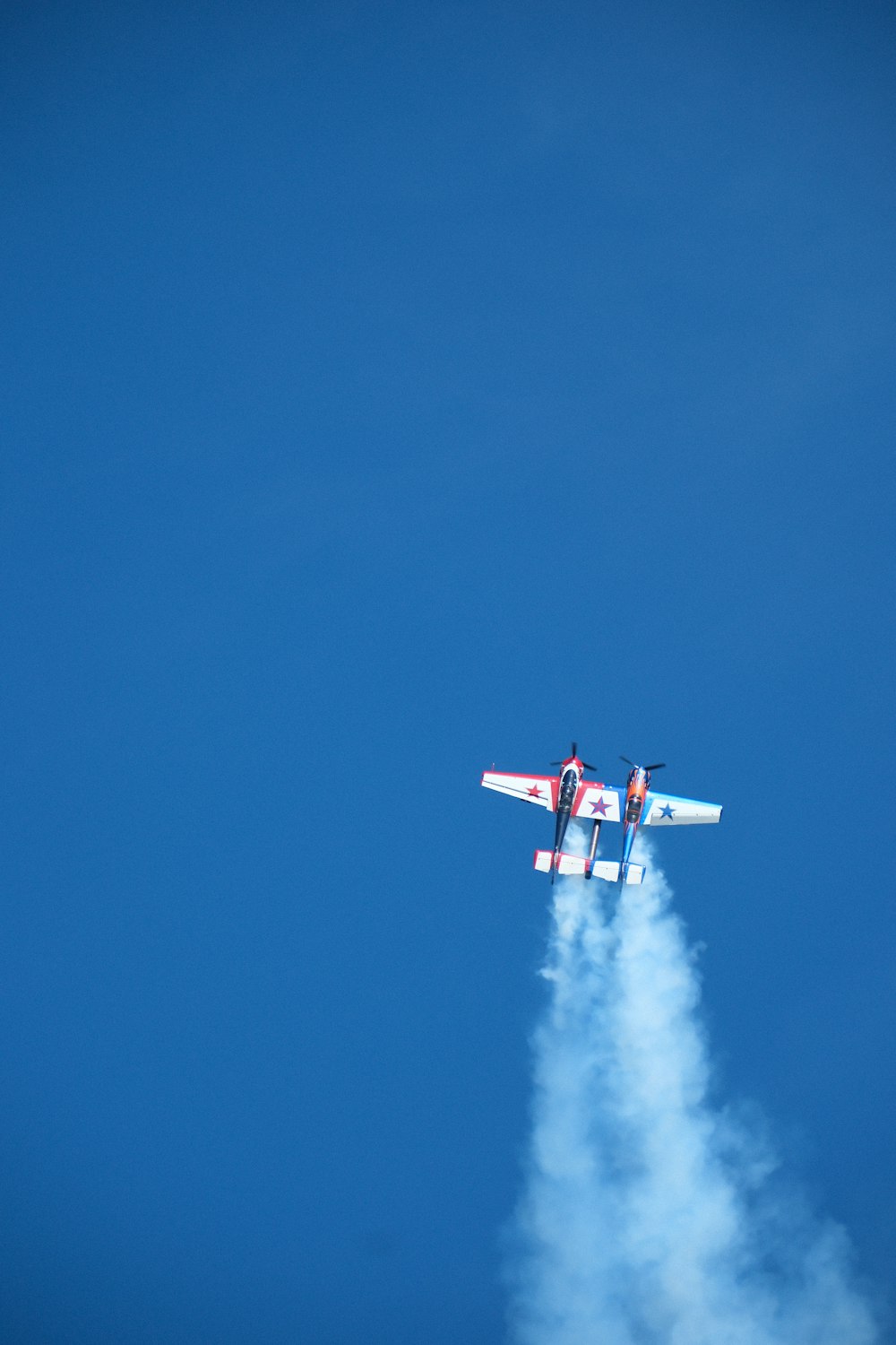 a small plane flying through a blue sky