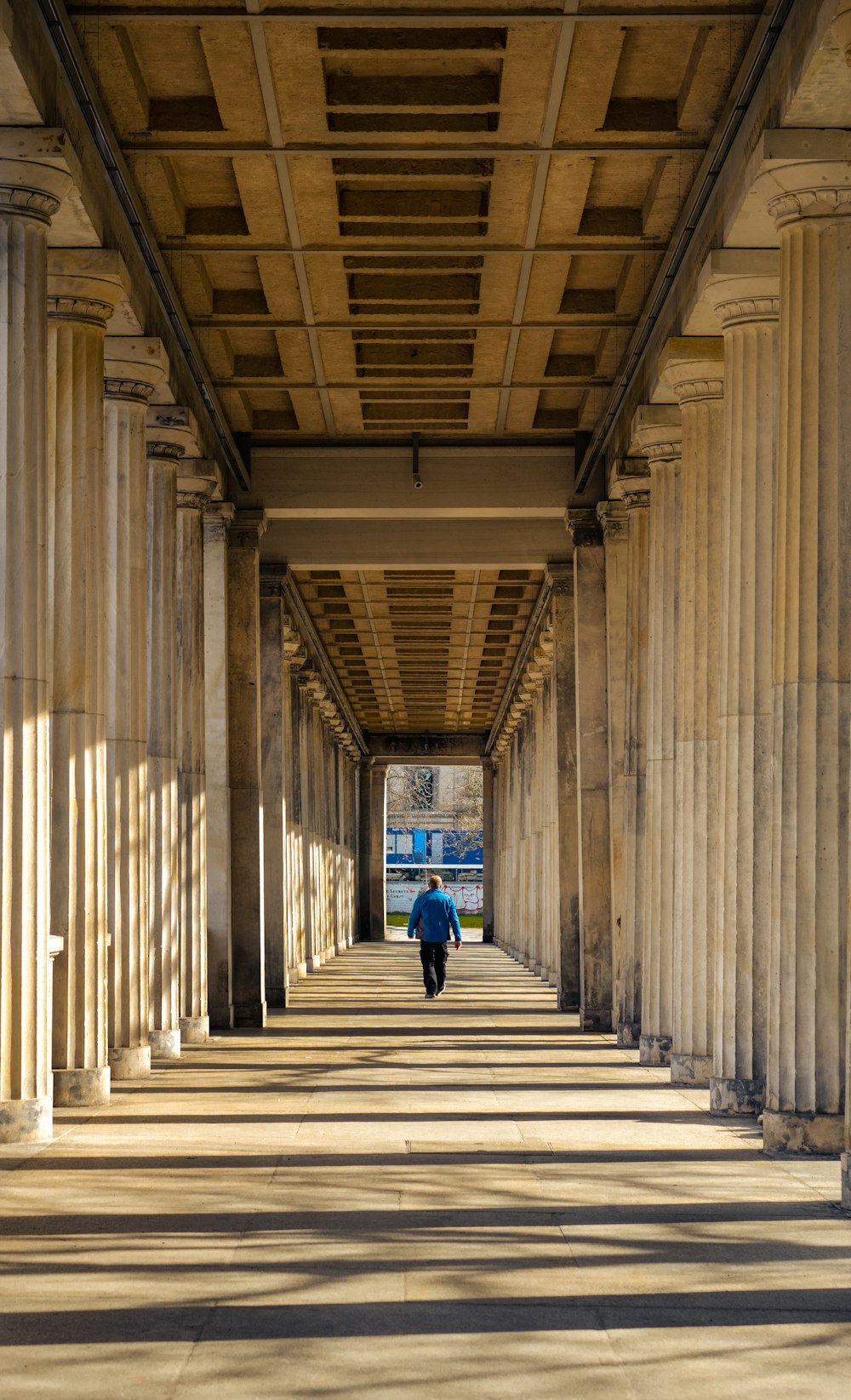 a person walking down a walkway under a bridge
