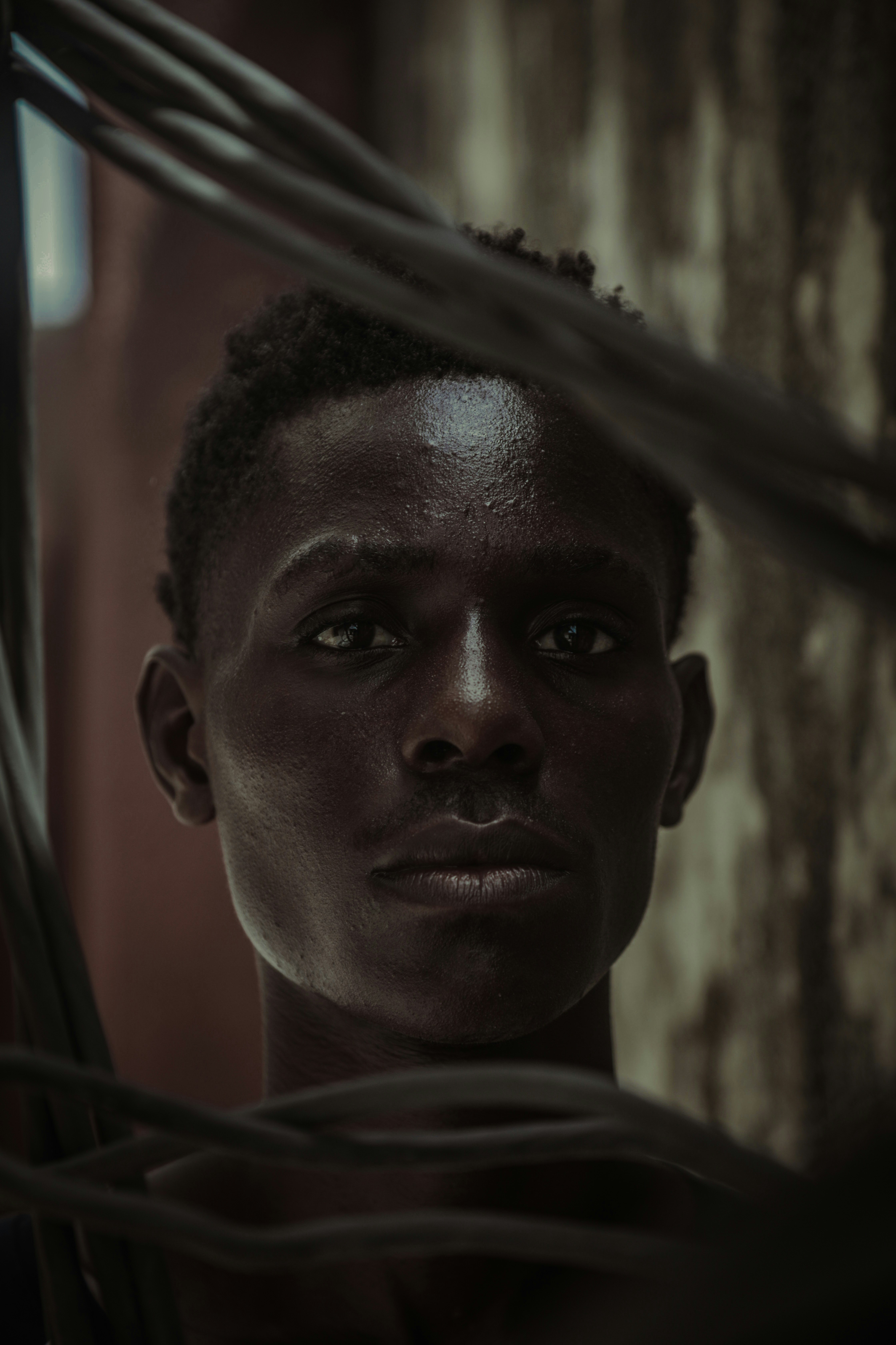 a young man is standing in front of a wall