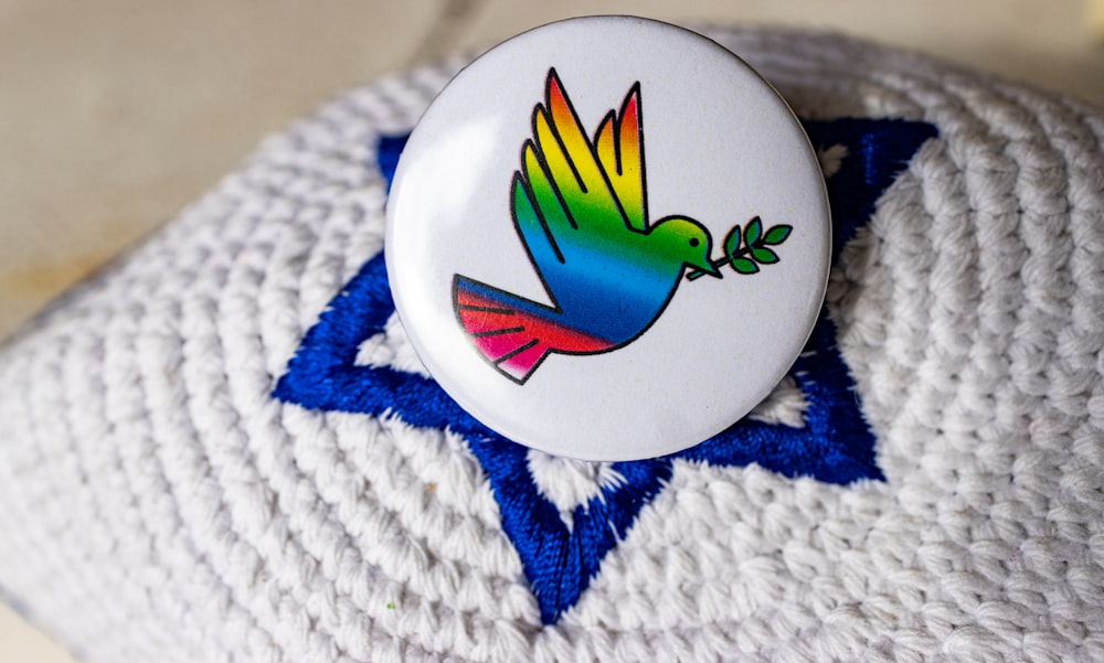 a white button with a colorful bird on it