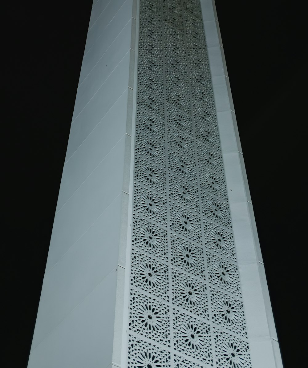 a tall white building with a decorative design on it's side