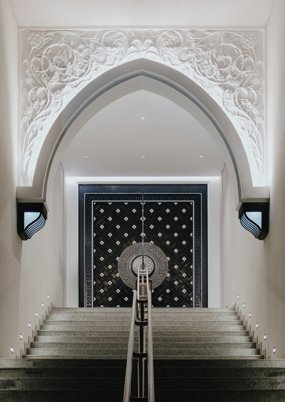 a staircase leading up to a doorway with a clock on it